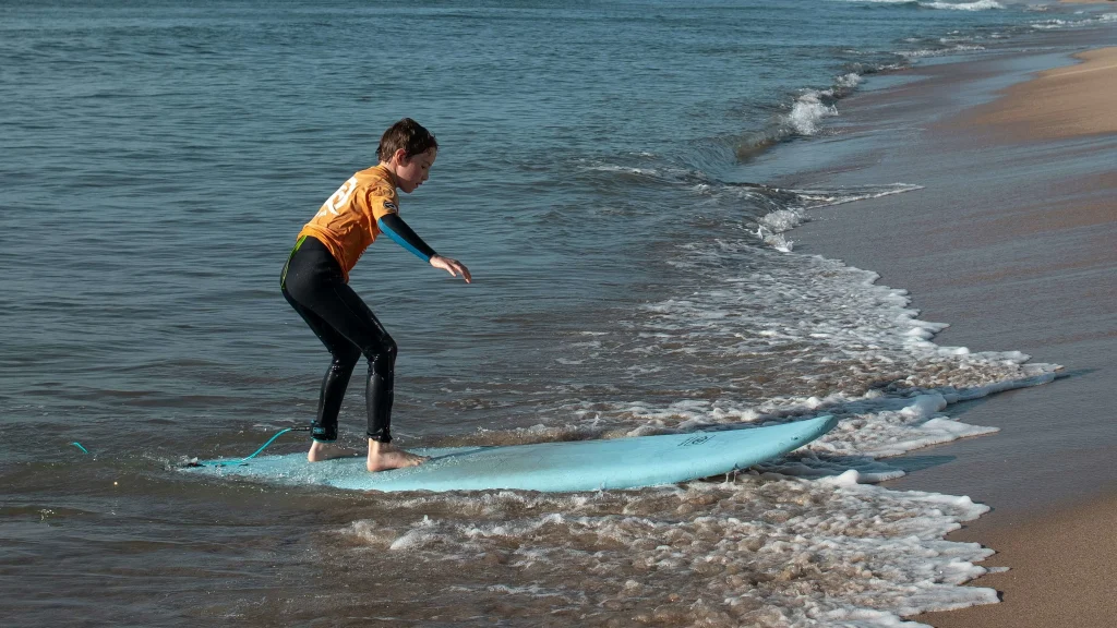 Surfing in Morocco for Beginners: A Local’s Ultimate Guide a kid surfing for the first time in Morocco beach